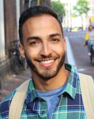 Handsome ethnic young male smiling outdoors.